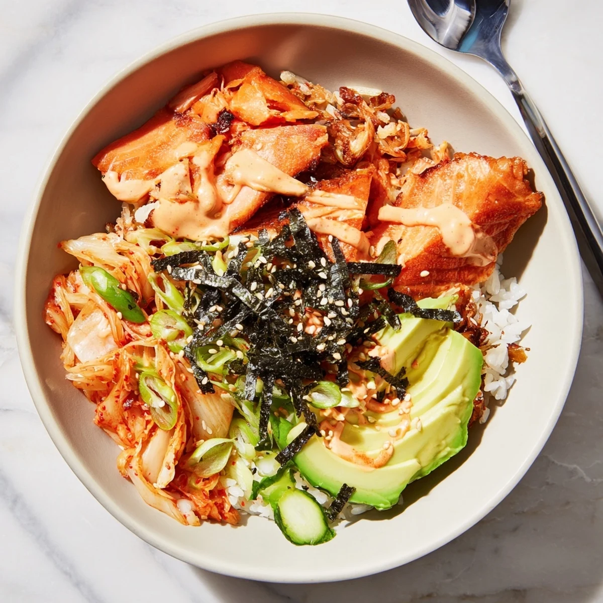 Crispy Salmon Rice Bowl topped with spicy mayo, avocado, and savory kimchi.  