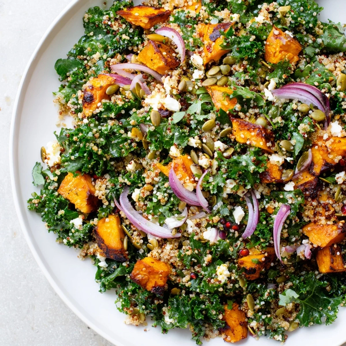 A bright, inviting photo of Kale & Quinoa Salad, showcasing sweet potato and a lemon dressing.