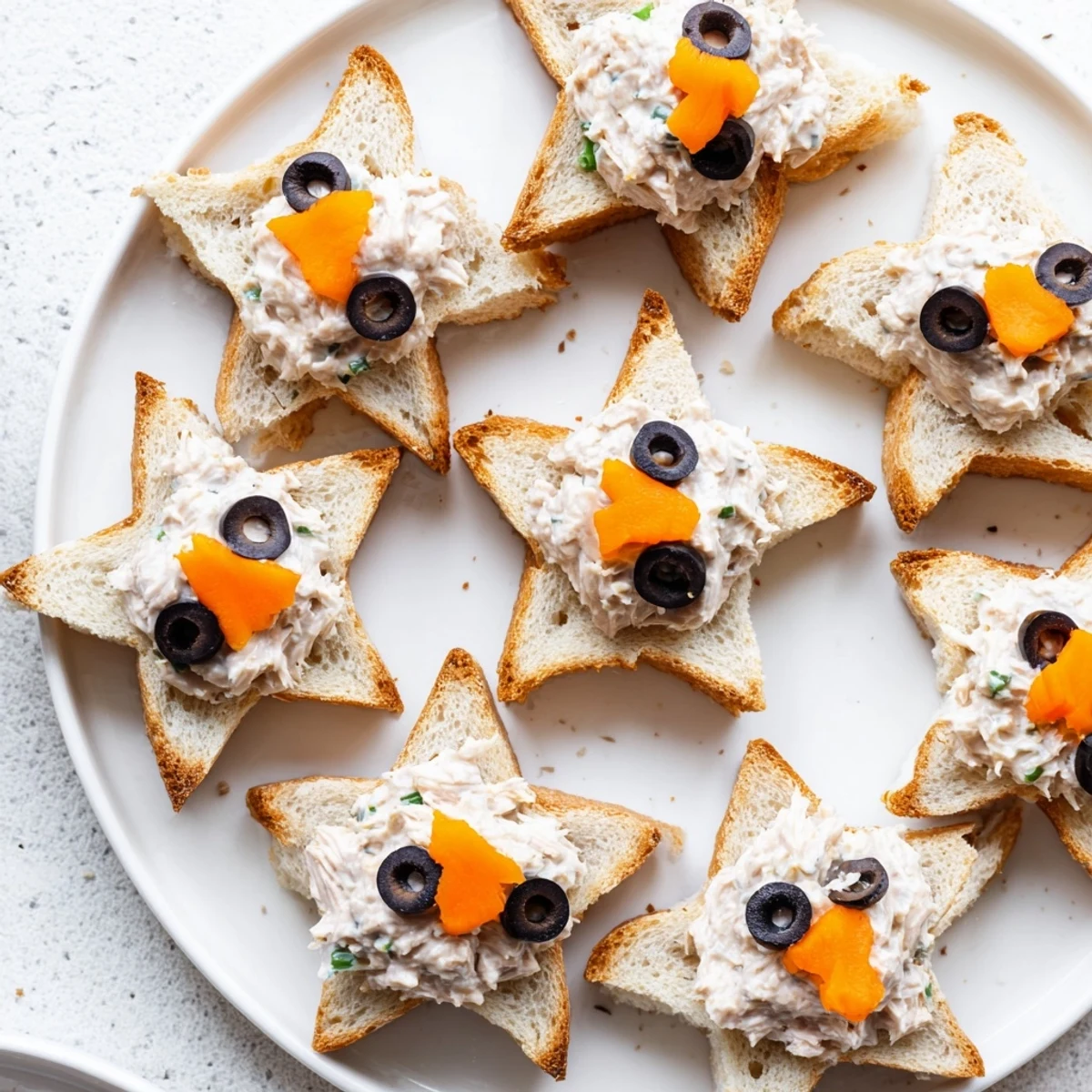 Mini Starfish Sandwiches: delightful tuna sandwiches shaped as stars, ready for a fun snack plate.