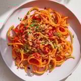Freshly tossed Carrot Ribbon Salad Asian-Style featuring ribbons of carrots and crunchy sesame seeds.