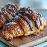 Buttery, tangy sourdough croissants filled with rich dark chocolate, perfect for a decadent breakfast or brunch treat.  