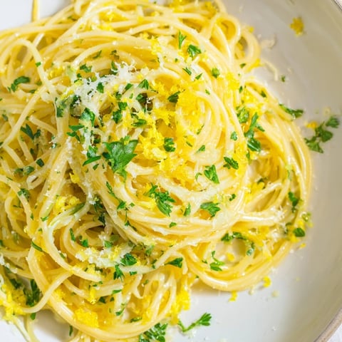 Steaming bowl of Lemon Capellini with fresh herbs, a bright and flavorful Italian pasta dish.