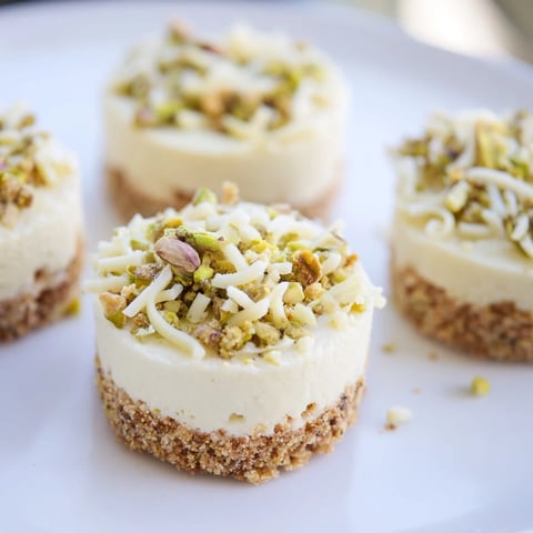 Mini Pistachio Cheesecake Bites shown, topped with chopped pistachios, creamy and decadent for dessert.