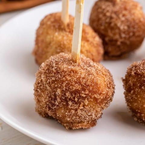 Bite-sized muffin pops, coated in cinnamon sugar, perfect for cozy breakfasts or snacks.  