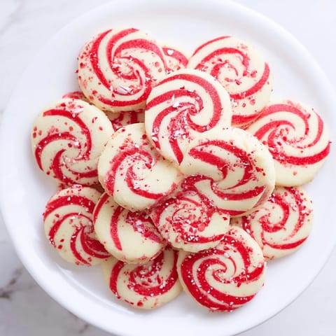 Delicious freshly baked Candy Cane Swirl Cookies featuring vibrant red swirls, speckled with candy.