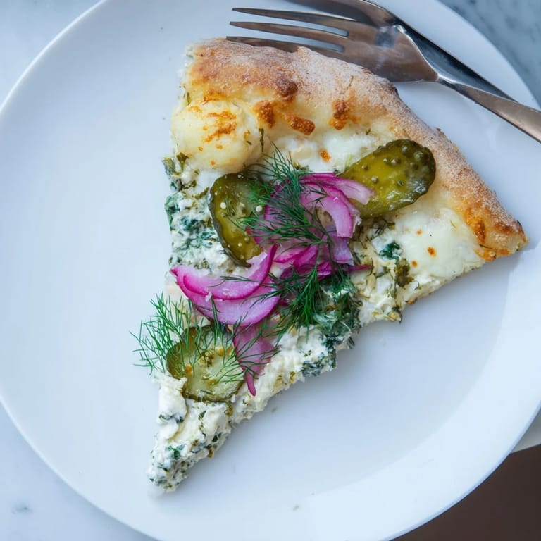 Mouthwatering Pickle Pizza featuring a rich crème fraîche sauce and crunchy toppings.
