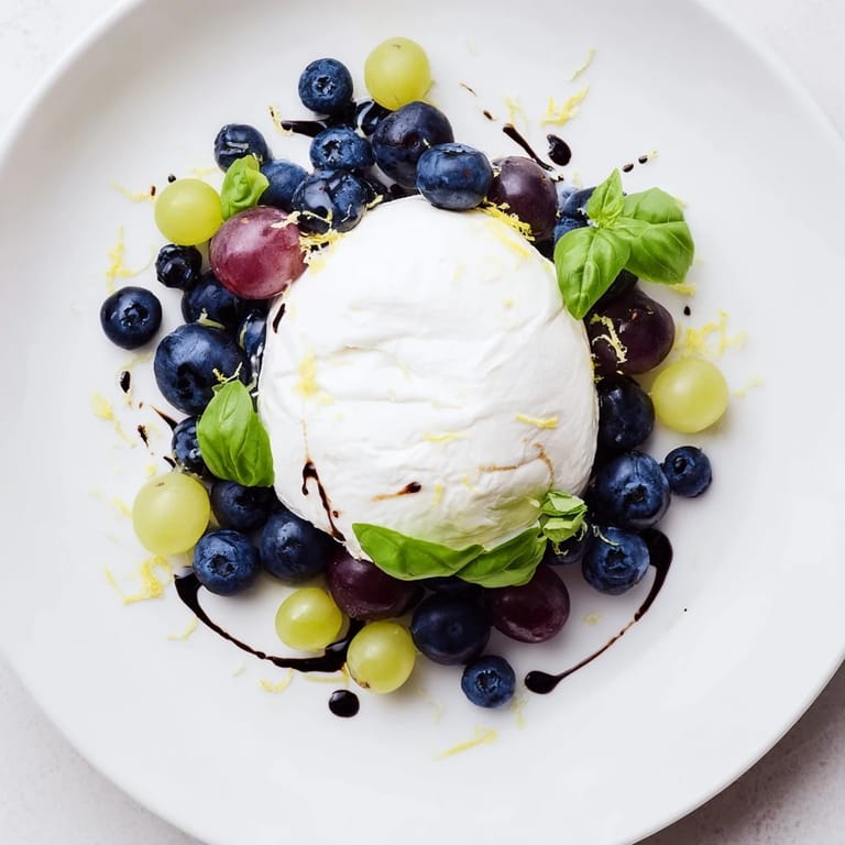 A close-up of The Moonlit Lagoon salad: berries and basil surrounded a creamy burrata cheese.