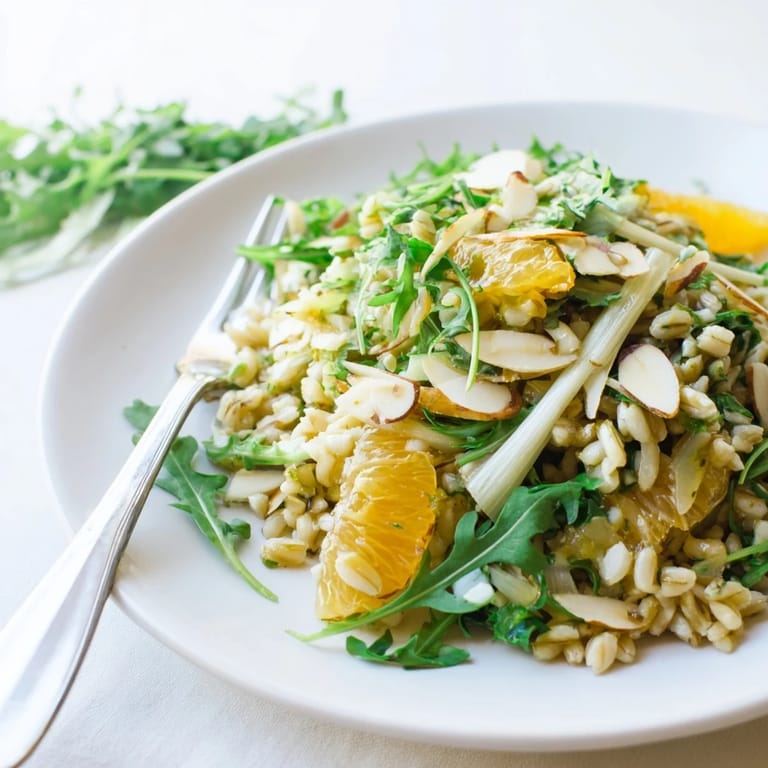 Chilled farro salad with vibrant fennel, juicy orange slices, and golden toasted almonds, drizzled with lemon-orange vinaigrette.